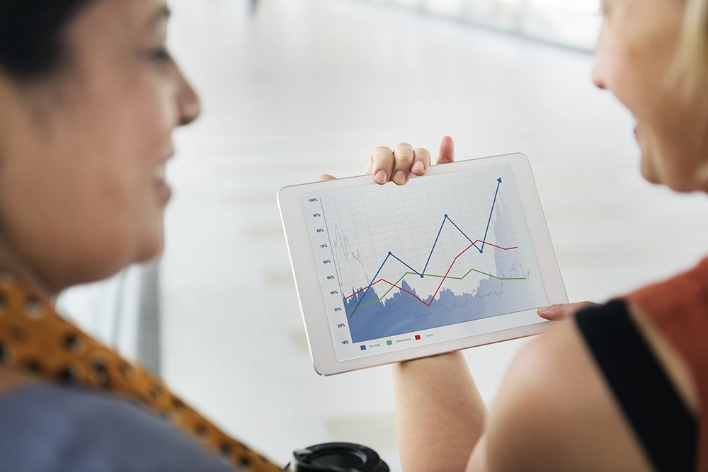 Deux personnes regardant un graphique sur une tablette.