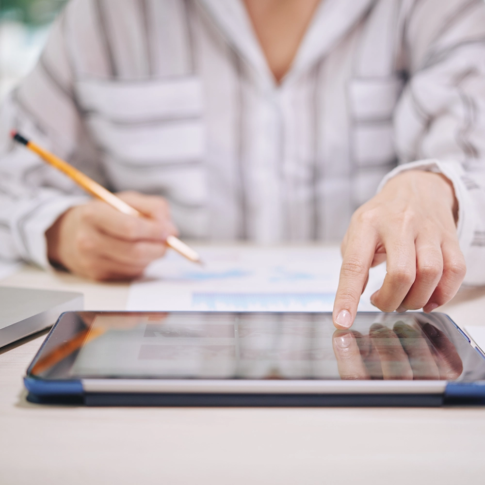 Personne utilisant une tablette pour consulter des documents.